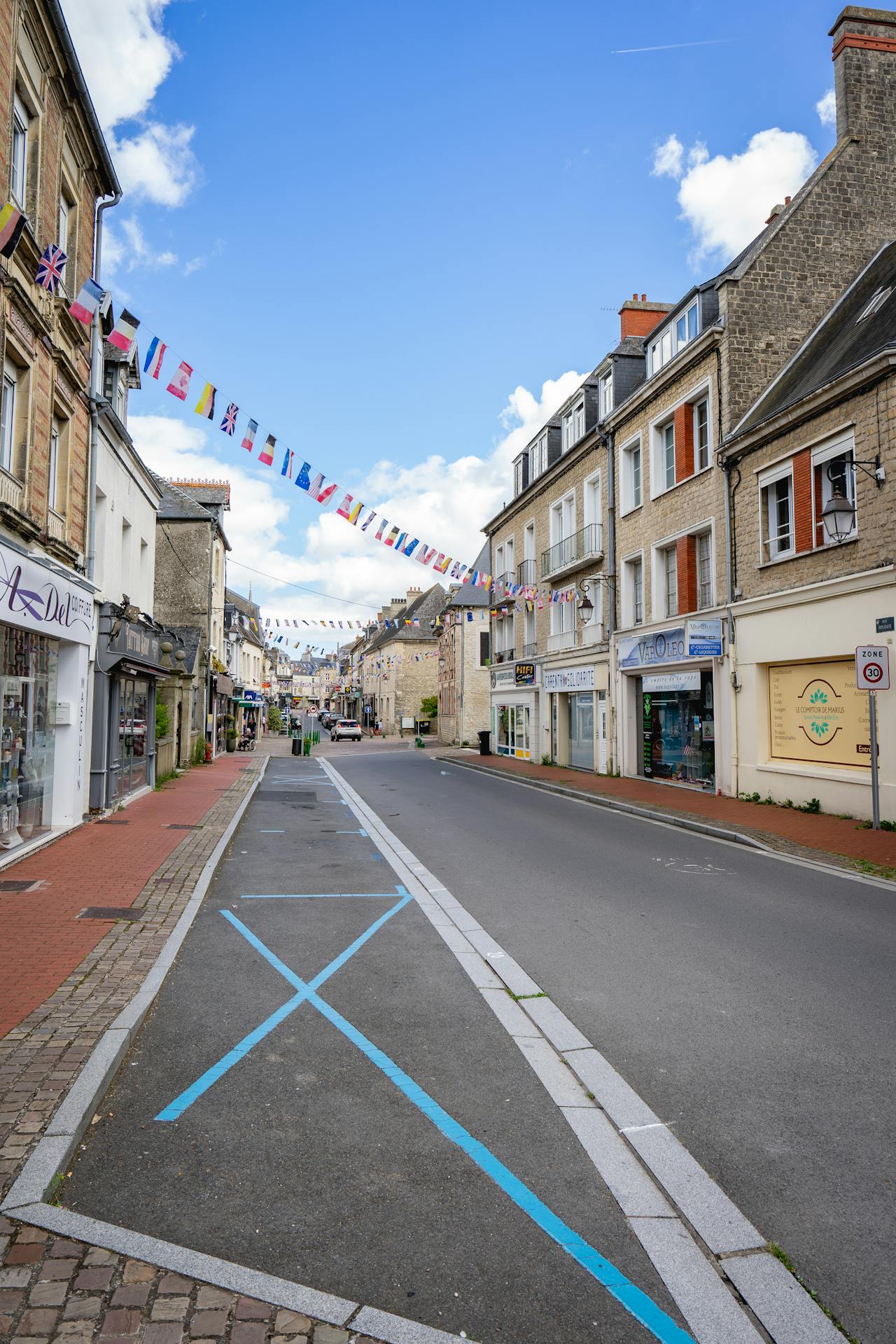 Middeleeuwse huizen met arcaden en een kerk in het historische centrum van Carentan-les-Marais, vlakbij Camping La Baie des Veys.
