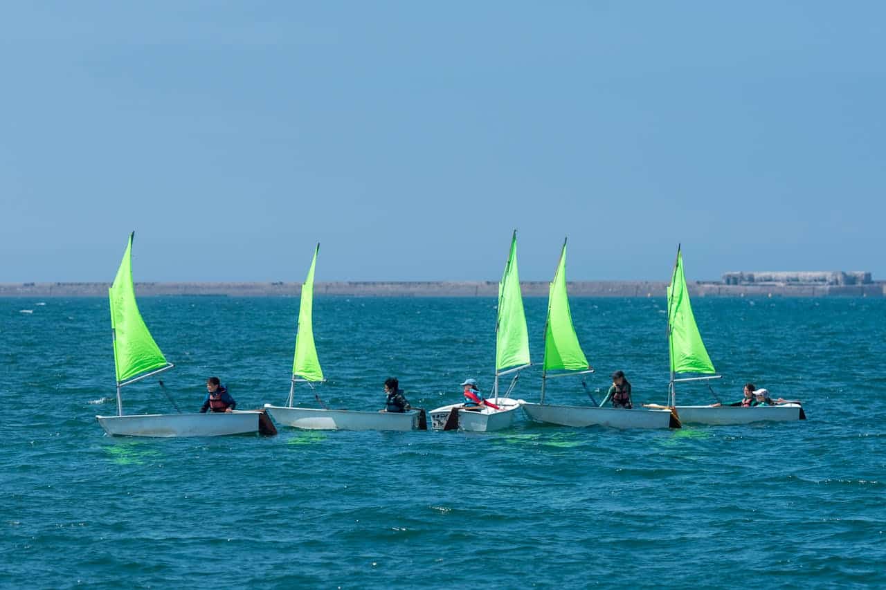 optimistische mouw Kinderen leren zeilen in Optimist-boten in de veilige jachthaven van Carentan, vlakbij de camping.