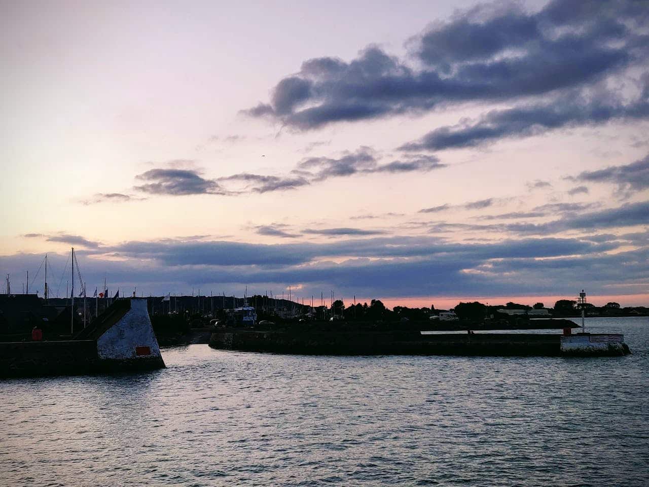Vissersboten aangemeerd in de haven van Saint-Vaast-la-Hougue met uitzicht op de Vauban-torens en de amfibieboot op weg naar het eiland Tatihou.